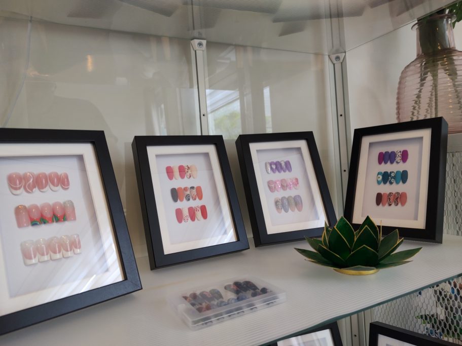 Lijst van ingelijste kunstwerken met kleurrijke patronen en een groene plant ervoor.