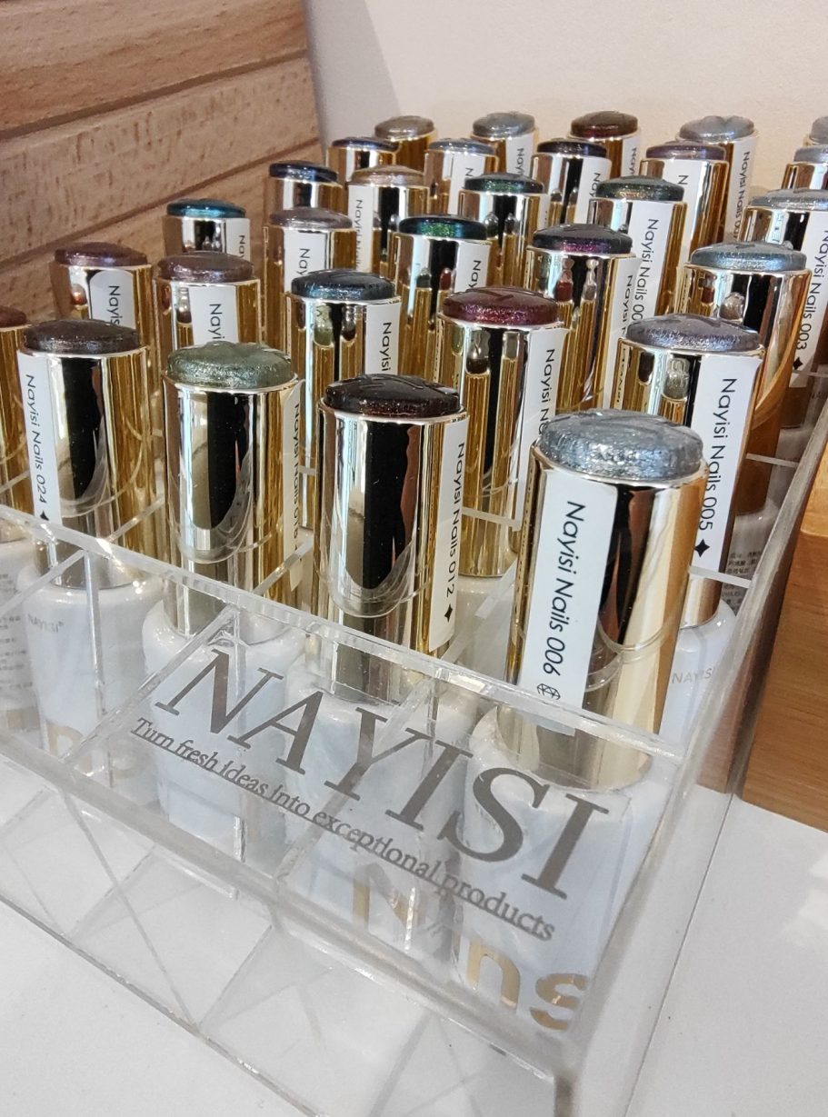 Een rij met parfumflessen in een doorzichtige houder, met gouden accenten.