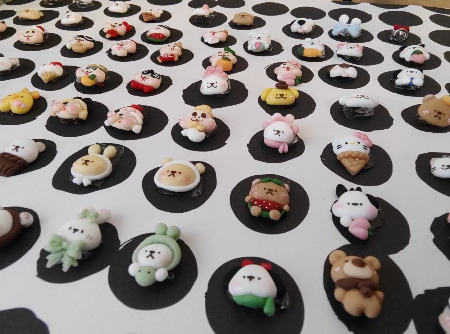 Schattige, kleurrijke miniatuurfiguren op een vlakke, zwart-witte ondergrond.